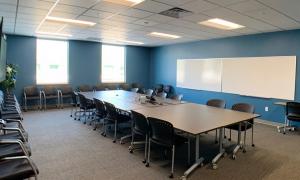 Tables, chairs and whiteboard in Moorhead Lecture Hall