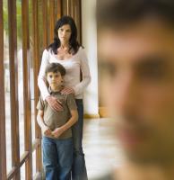 mom and son looking sad behind blurred man